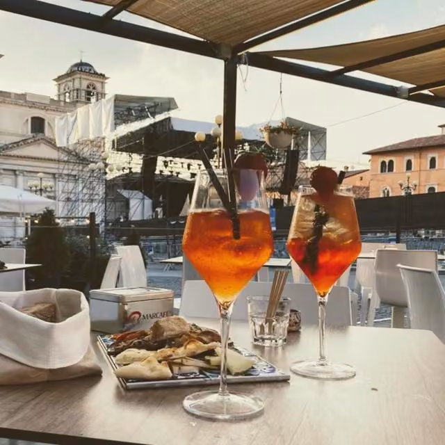 Due drink su un tavolo con un piatto di cibo in un locale del centro storico