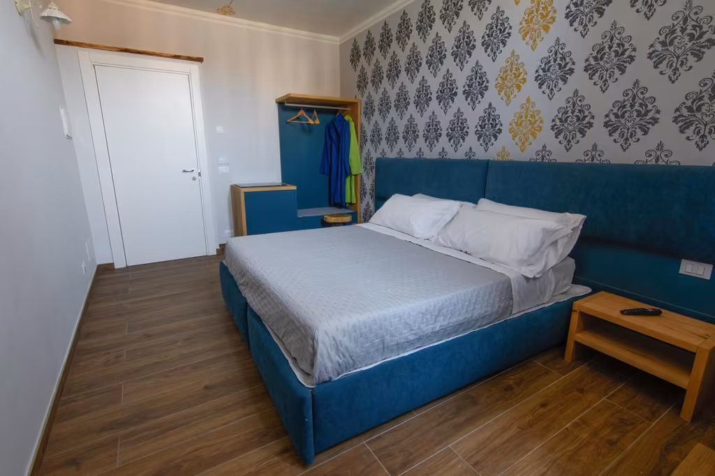 Camera Doppia Torre, letto matrimoniale con testiera blu, del B&B Piazza del Mercato all'Aquila